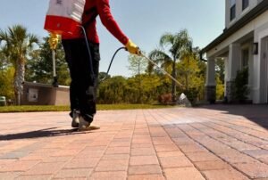 Professional pressure washing technician cleaning a Brisbane driveway to remove oil stains and restore surface appearance