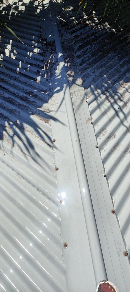 Colorbond roof mid-clean in Brisbane — mould and staining lifting to reveal a clean metal surface