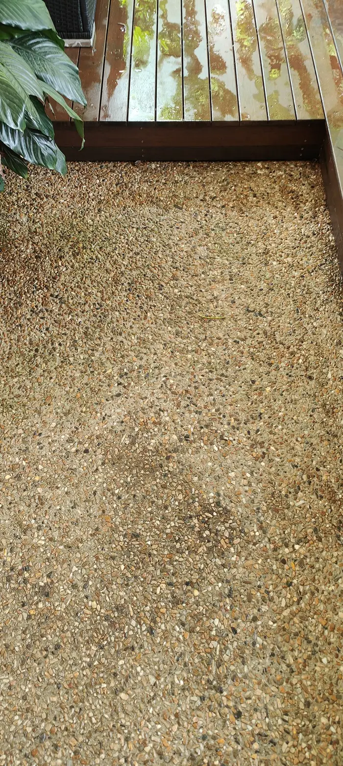 Freshly cleaned exposed aggregate concrete patio beside a timber deck in Brisbane