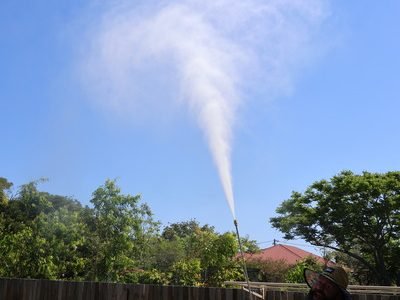 Pressure cleaning professional in Ipswich holding washer and pointing upward
